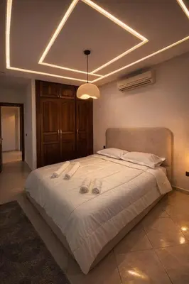 a bedroom with a large bed with slippers on it at Appartement 2 Chambres 2 Balcons Gueliz in Marrakech