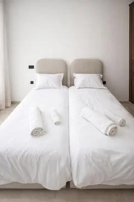 two beds with white sheets and towels on them at Appartement 2 Chambres 2 Balcons Gueliz in Marrakech
