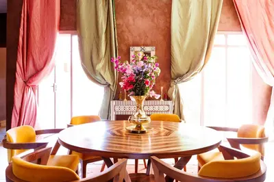 a dining room with a table with a vase of flowers at Villa Romana in Marrakech