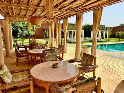 a patio with a table and chairs and a pool at Villa Romana in Marrakech