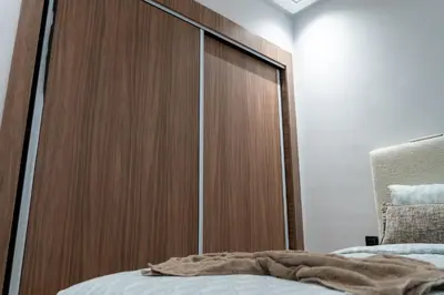 a large wooden closet in a bedroom with a bed at luxury white & beige Apartment in Marrakech