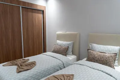 two beds sitting next to each other in a bedroom at luxury white & beige Apartment in Marrakech