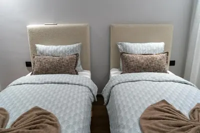 two beds sitting next to each other in a room at luxury white & beige Apartment in Marrakech