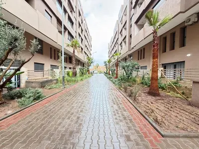 a cobblestone street in a building with palm trees at luxury white & beige Apartment in Marrakech