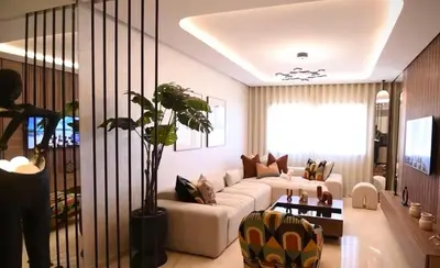 a living room with a white couch and a plant at Luxury Apartment in Marrakech