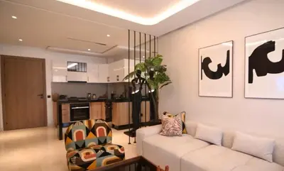 a living room with a white couch and a kitchen at Luxury Apartment in Marrakech