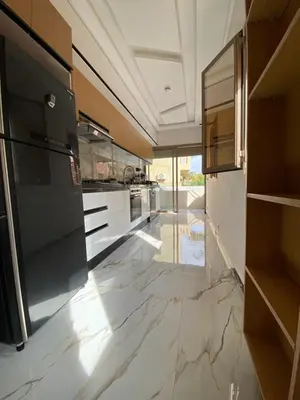 a kitchen with marble flooring and a large appliance at Appartement neuf et équipé, proche de commodités in Marrakech