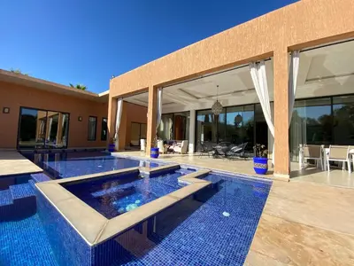 a house with a swimming pool in front of a house at Villa Ines Piscine chauffée & Jacuzzi & Hammam in Marrakech