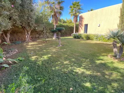 a yard with palm trees and a building at Villa Ines Piscine chauffée & Jacuzzi & Hammam in Marrakech