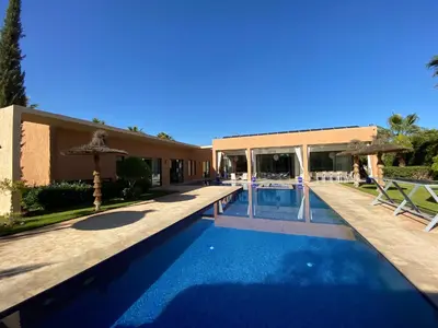 a swimming pool in front of a building at Villa Ines Piscine chauffée & Jacuzzi & Hammam in Marrakech
