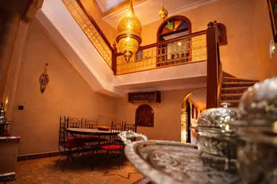 a room with a table and chairs and a staircase at Riad 16 Dar and Pool in Marrakech