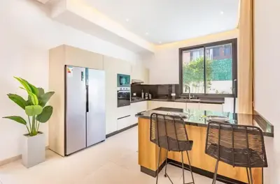 a kitchen with a counter and a refrigerator at Kais in El Rhechat