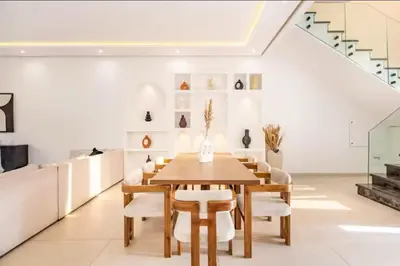 a dining room with a wooden table and chairs at Kais in El Rhechat