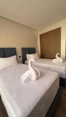two white swans sitting on two beds in a room at Marrakesh Heated Pool Sport and Jacuzzi in Marrakech