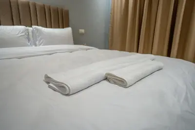 a white bed with two folded towels on it at The best JINANE in Marrakech