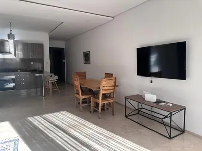 a living room with a table and a flat screen tv at Studio Premium au Cœur de Guéliz in Marrakech