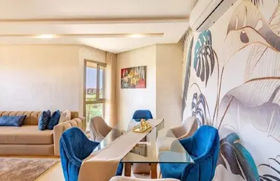 a living room with a couch and a table and chairs at Prestigia Golf Resort Luxury in Marrakech