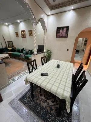 a living room with a table and a couch at Appartement familial Marrakech in Marrakech
