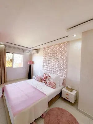 a bedroom with a large bed with pink sheets and a window at Appartement de luxe Marrakech - Targa in Marrakech