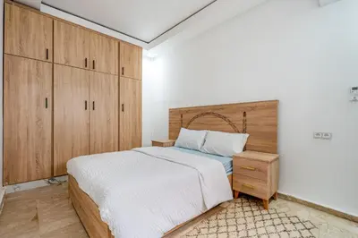 a bedroom with a large bed and wooden cabinets at Horizon Cozy terrace and serenity in Marrakech