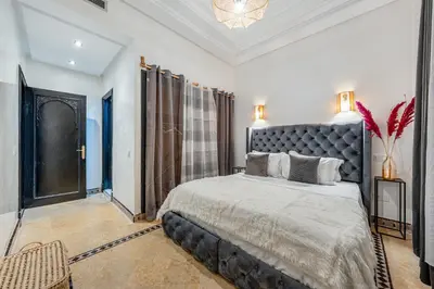 a bedroom with a large bed with a black headboard at Andalusian Dream Villa pool and balcony in Marrakech