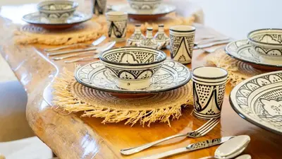 a wooden table with plates and utensils on it at Majorelle Garden - Design apartment in Marrakech