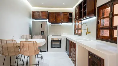 a kitchen with a sink and a table and chairs at Majorelle Garden - Design apartment in Marrakech
