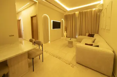 a living room with a white couch and a table at Prestigia Exceptional apartment with pool view in Marrakech