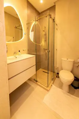 a bathroom with a shower and a toilet and a sink at Prestigia Exceptional apartment with pool view in Marrakech