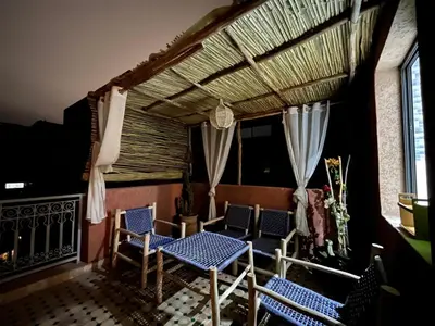 a balcony with chairs and a table and a roof at Amjad in Marrakech