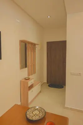 a living room with a table and a mirror at Spacious Apartment with AC & Fast WiFi 5 Guests in Marrakech