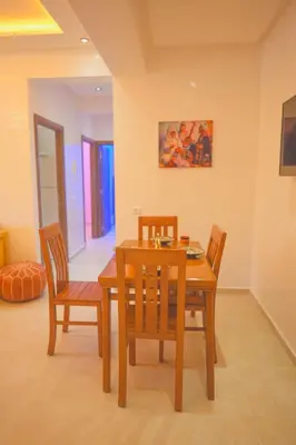 a dining room with a wooden table and chairs at Spacious Apartment with AC & Fast WiFi 5 Guests in Marrakech
