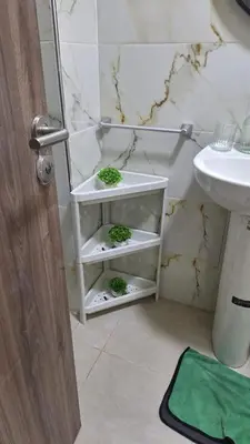 a bathroom with a white shelf with plants on it at Spacious Apartment with AC & Fast WiFi 5 Guests in Marrakech