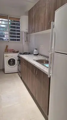 a kitchen with a white refrigerator and a sink at Spacious Apartment with AC & Fast WiFi 5 Guests in Marrakech