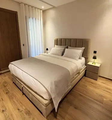 a bedroom with a large bed with white sheets at Appartement vue piscine & fitness à Guéliz in Marrakech