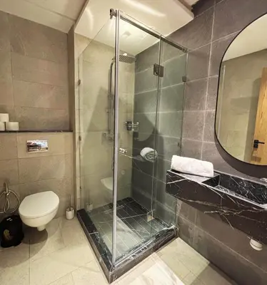 a bathroom with a glass shower and a toilet at Appartement vue piscine & fitness à Guéliz in Marrakech