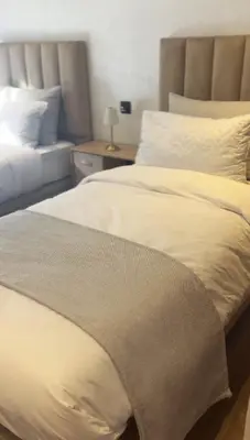a bedroom with two beds and a table with a lamp at Appartement vue piscine & fitness à Guéliz in Marrakech