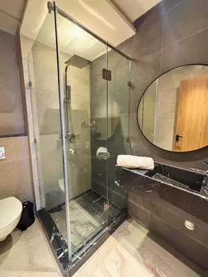 a bathroom with a glass shower with a toilet at Appartement vue piscine & fitness à Guéliz in Marrakech