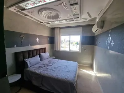 a bedroom with a bed with a ceiling and a window at Appartement Laila Guéliz - Victor Hugo in Marrakech