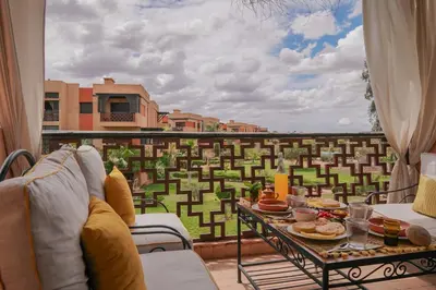 a balcony with a table with food on it at Stylish Apartment with Pool in Marrakech in Marrakech