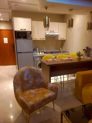 a living room with a kitchen with a chair and a table at Duplex High Standing-0 Fees Service-10 min Gueliz in Marrakech