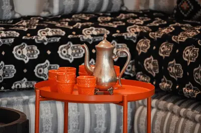 a tray with a tea kettle and cups on a table next to a bed at Berber House Authentic Moroccan Farm Stay in El Rhechat