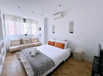 a white bedroom with a large bed and a couch at Villa nakhil in Marrakech