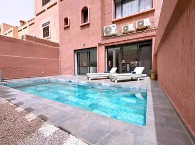a swimming pool in front of a building at Villa nakhil in Marrakech