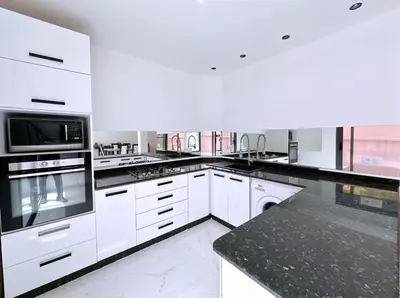 a kitchen with white appliances and black counter tops at Villa nakhil in Marrakech
