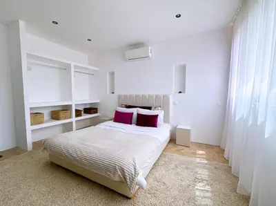 a white bedroom with a bed with two pink pillows at Villa nakhil in Marrakech