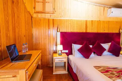a bedroom with a bed with a laptop on a desk at Ferme dhôte Sidi Safou Cabane en bois Marrakech in Marrakech