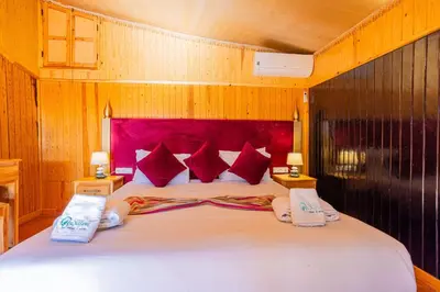 a bedroom with a large white bed with red pillows at Ferme dhôte Sidi Safou Cabane en bois Marrakech in Marrakech