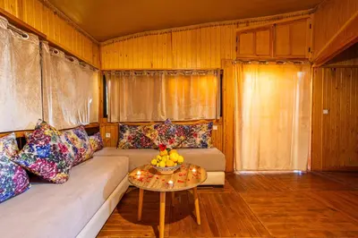a living room with a couch and a table at Ferme dhôte Sidi Safou Cabane en bois Marrakech in Marrakech