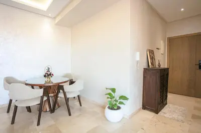 a dining room with a wooden table and white chairs at 2 bedroom apartment, 4 people, near Jardin Majorelle in Marrakech